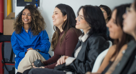 Mehrere Frauen sitzen nebeneinander und sehen nach links. Es scheint sich um eine Unterrichtssituation zu handeln. Die Frauen sind nur mit Köpfen und teilweise Oberkörper zu sehen.